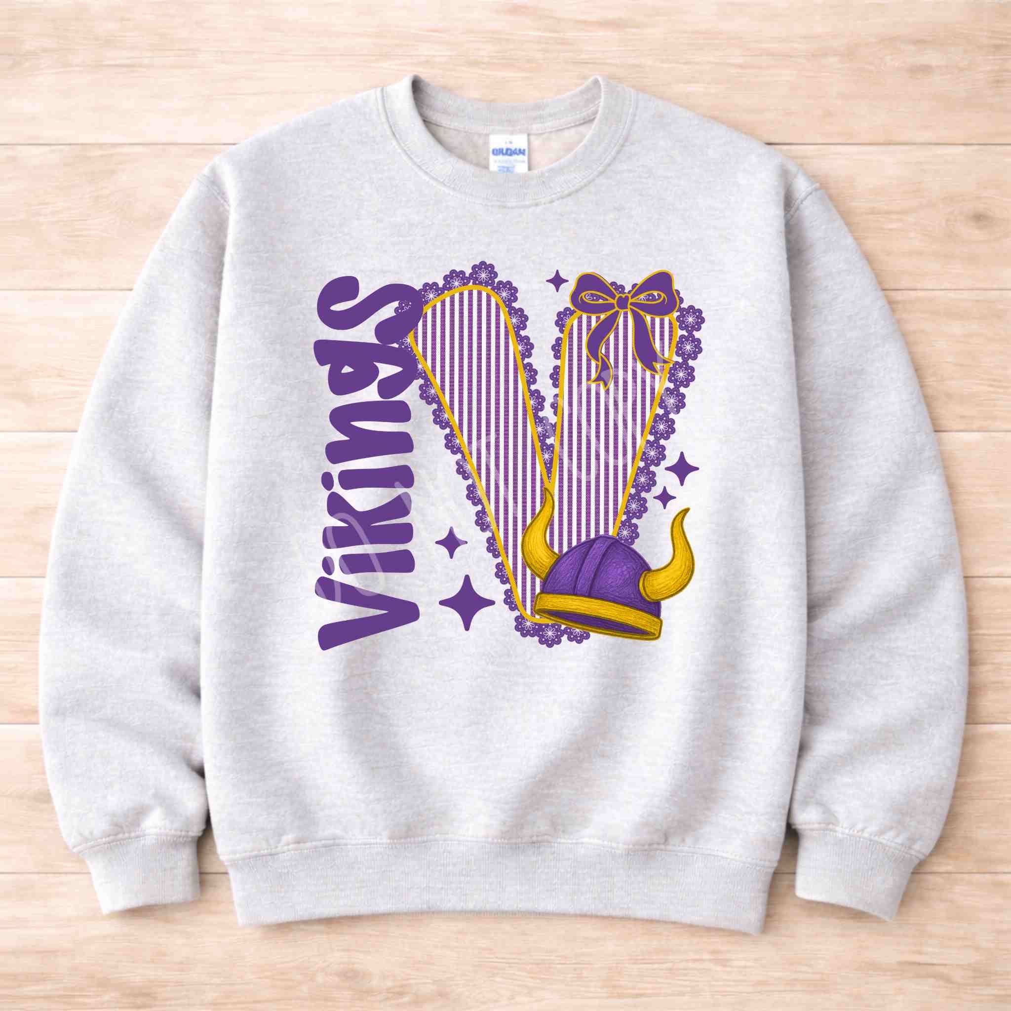 Vikings School Spirit Sweatshirt featuring bold varsity letters and a purple bow design.