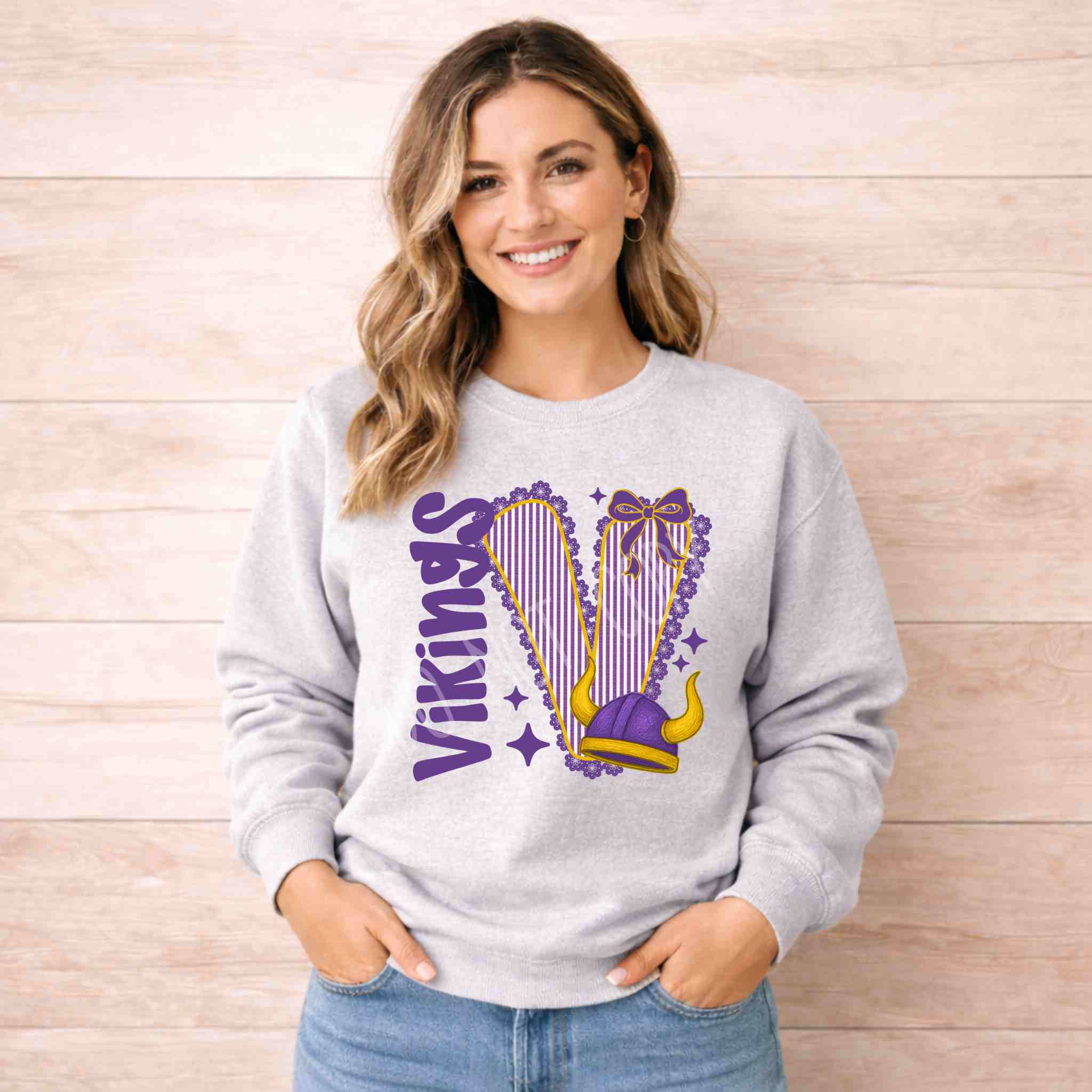Vikings School Spirit Sweatshirt featuring a varsity graphic and bow accent on a light gray crewneck.