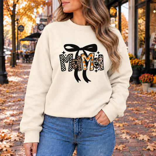 Cream crewneck sweatshirt with large black bow and checkered leopard letter graphic