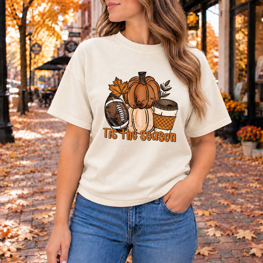 Cream fall graphic tee with pumpkins, a football, a coffee cup, and Tis the Season print