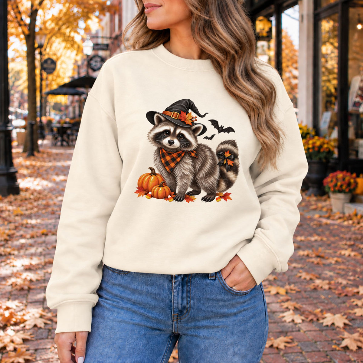 Cream crewneck sweatshirt with raccoon witch graphic and orange pumpkins, long sleeves