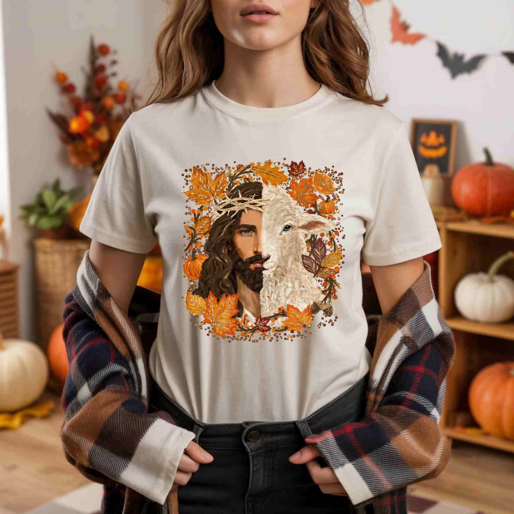 Person wearing a white t-shirt with a graphic design of a wolf and a person's face surrounded by autumn leaves and pumpkins.