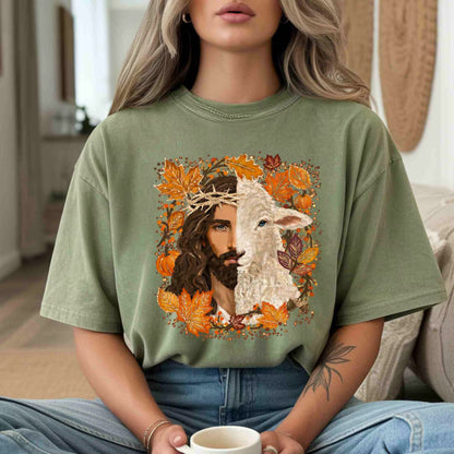 Person wearing a green t-shirt with a graphic design of a man holding a lamb and surrounded by autumn leaves.