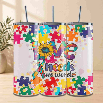 The Autism Awareness Love Needs No Words Tumbler – 20oz from Becca's Banging Designs LLC features a puzzle piece sunflower and ribbon, making it a meaningful gift for autism support or awareness.