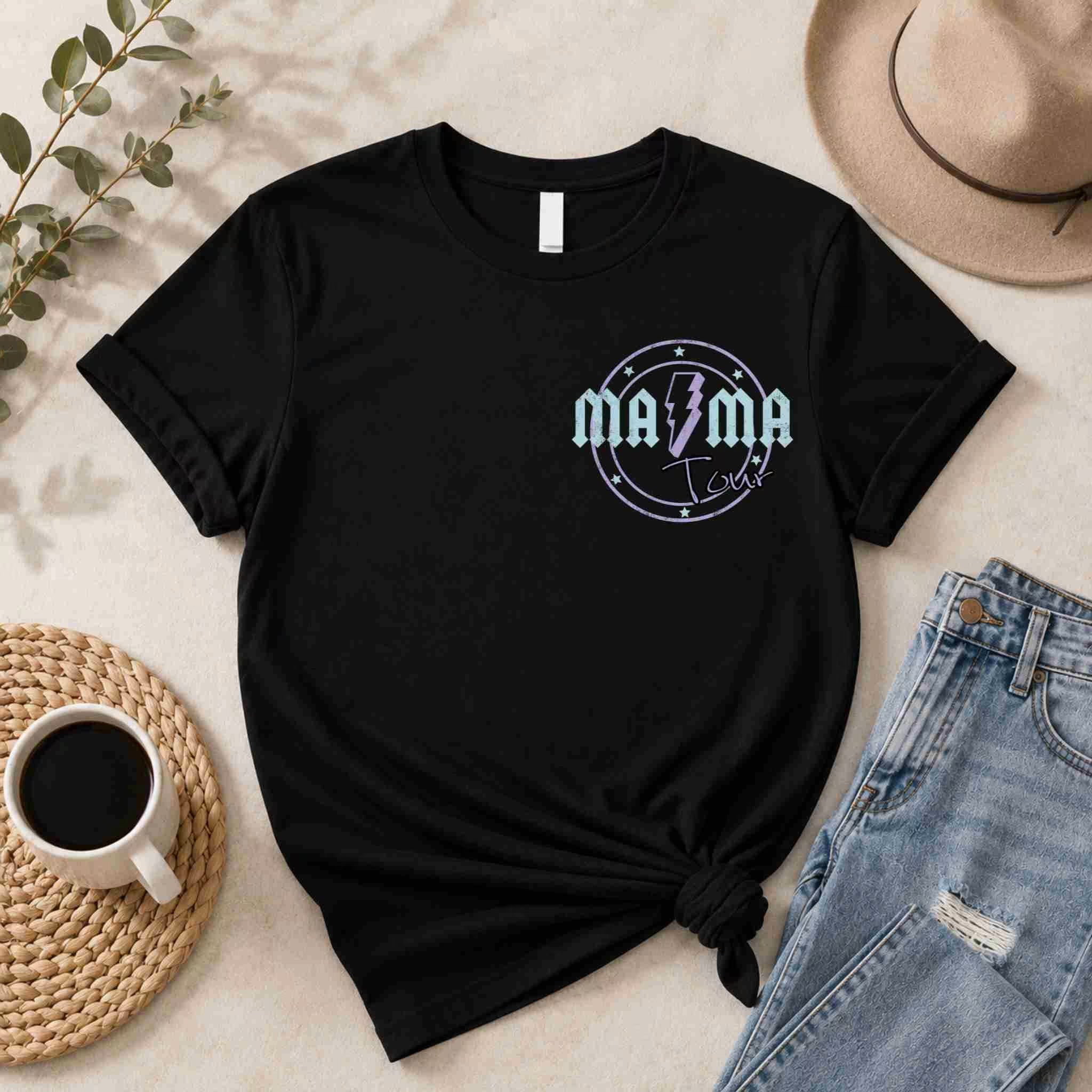 Black t-shirt with 'Mama' design on a light surface with casual items like jeans and a coffee cup.