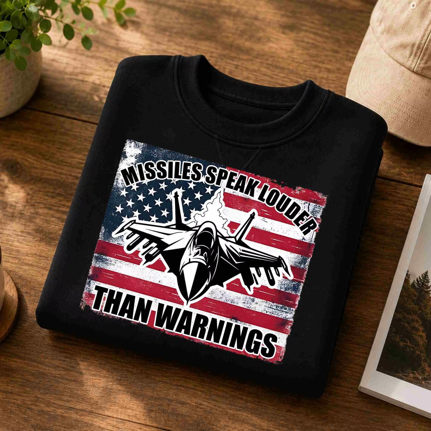 Black sweatshirt with American flag and airplane design on a wooden surface
