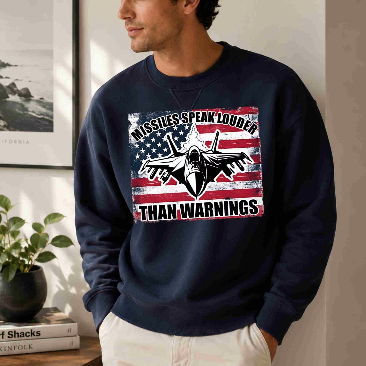Person wearing a navy blue sweatshirt with a graphic design and text in a room.