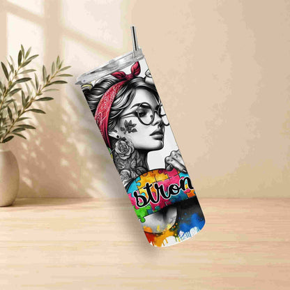 Tumbler with a design of a woman with glasses and a bandana, placed on a wooden surface with a plant in the background.