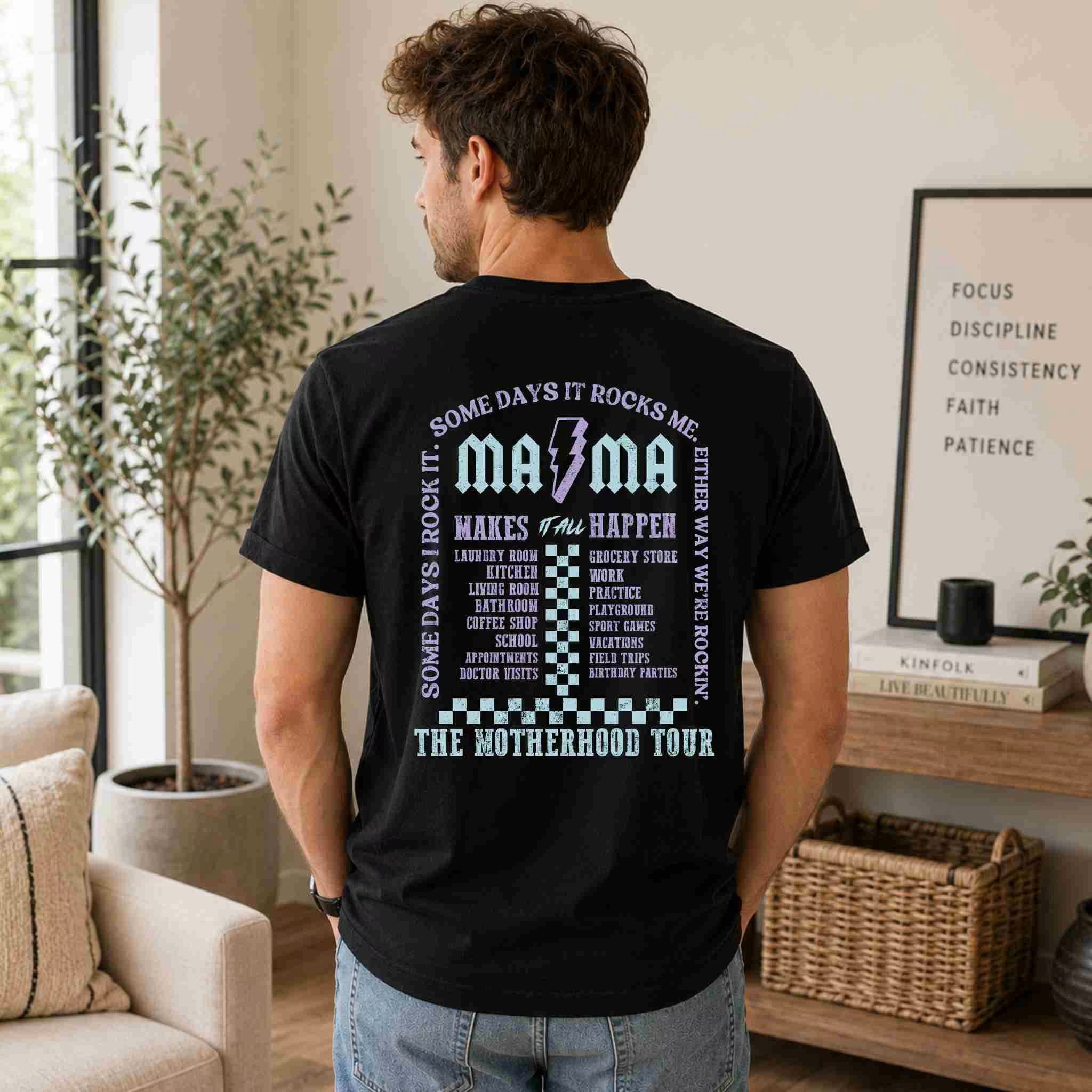 Man wearing a black t-shirt with text and graphics, standing in a living room.