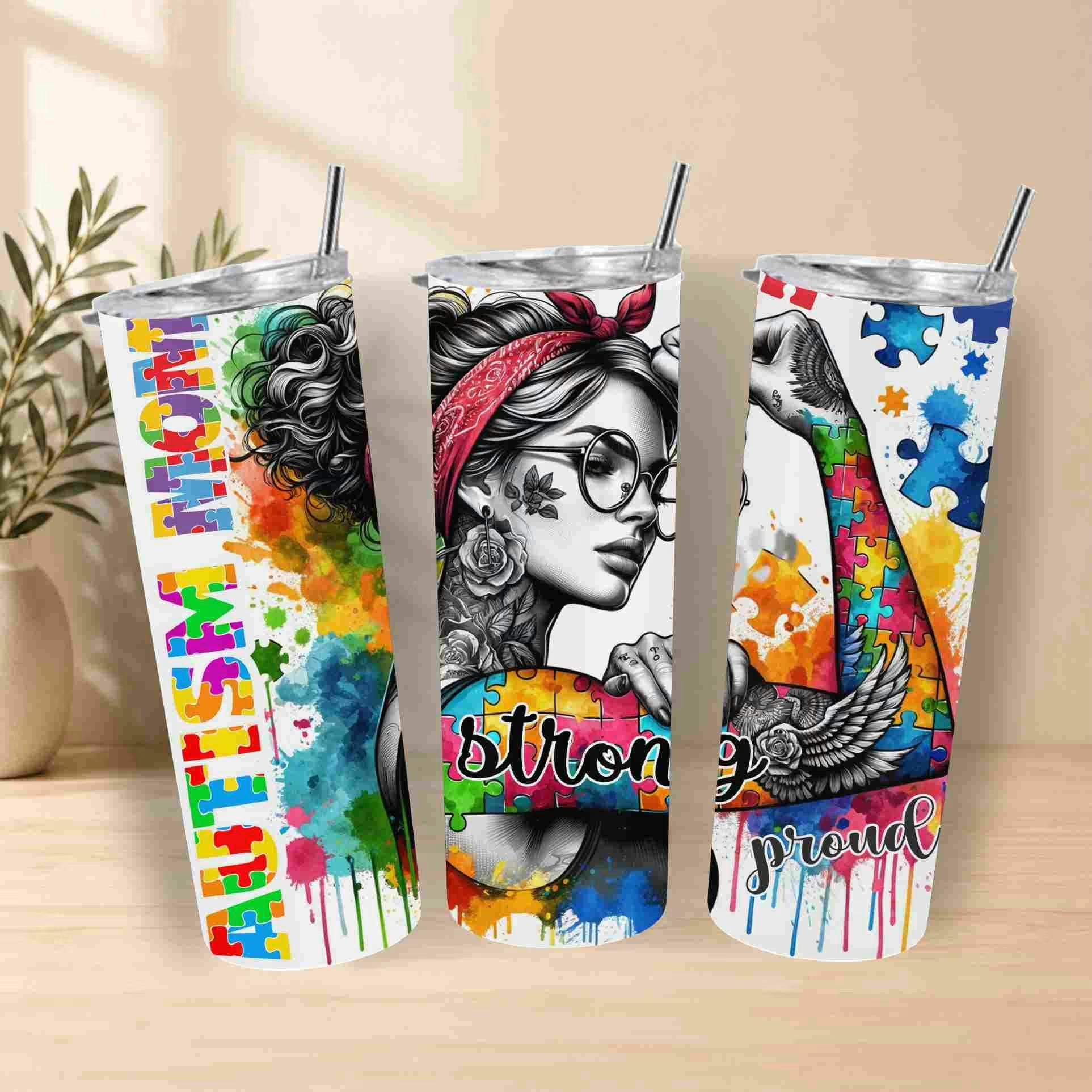Three colorful tumblers with motivational designs on a wooden surface.