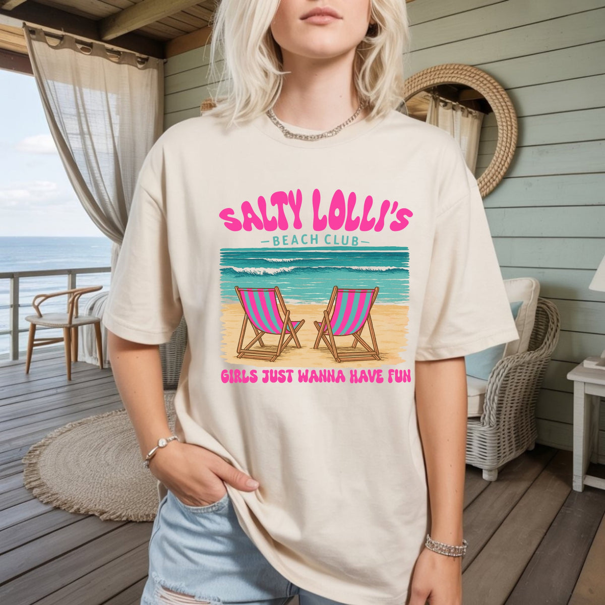 Women's beige graphic t-shirt with 'Salty Lolli's Beach Club' text and lounge chair graphic