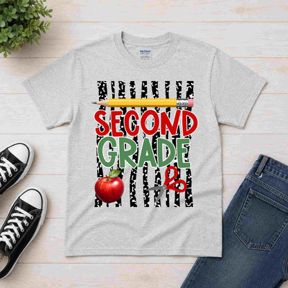 Gray t-shirt with 'Second Grade' design featuring a pencil, apple, and zebra print on a wooden surface with shoes and jeans.