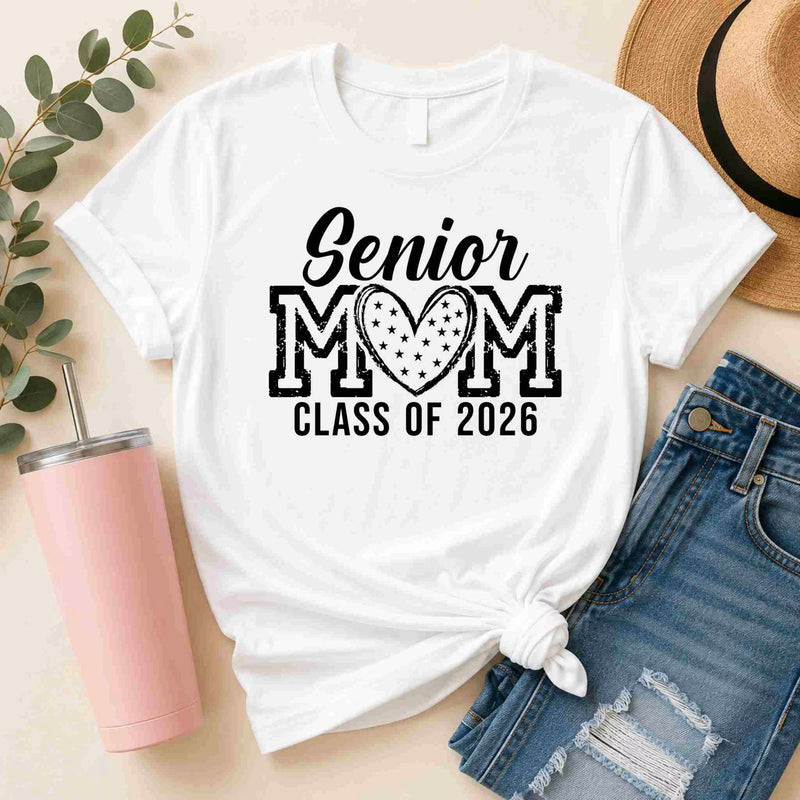 White t-shirt with 'Senior Mom Class of 2026' text, pink tumbler, and denim shorts on a light background
