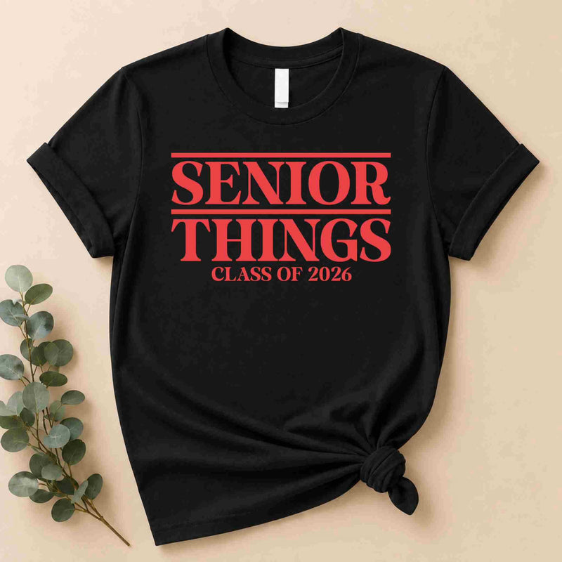 The Senior Things Shirt Class of 2026 Tee by Becca's Banging Designs LLC boasts bold red "Senior Things Class of 2026" text in a Stranger Things style—perfect as a funny senior year graduation outfit or last year vibes shirt.