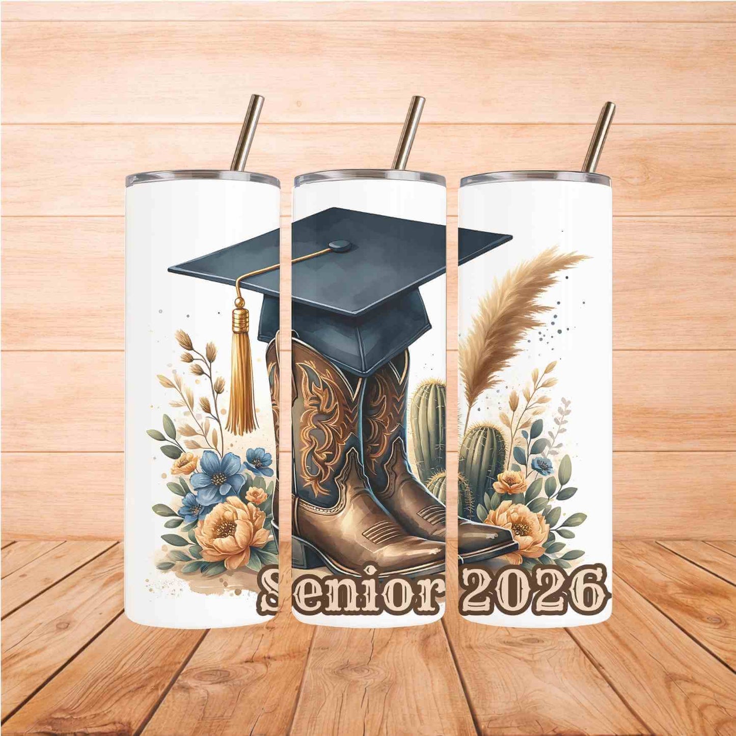 Tumbler with graduation cap, cowboy boots, and cactus design on a wooden surface