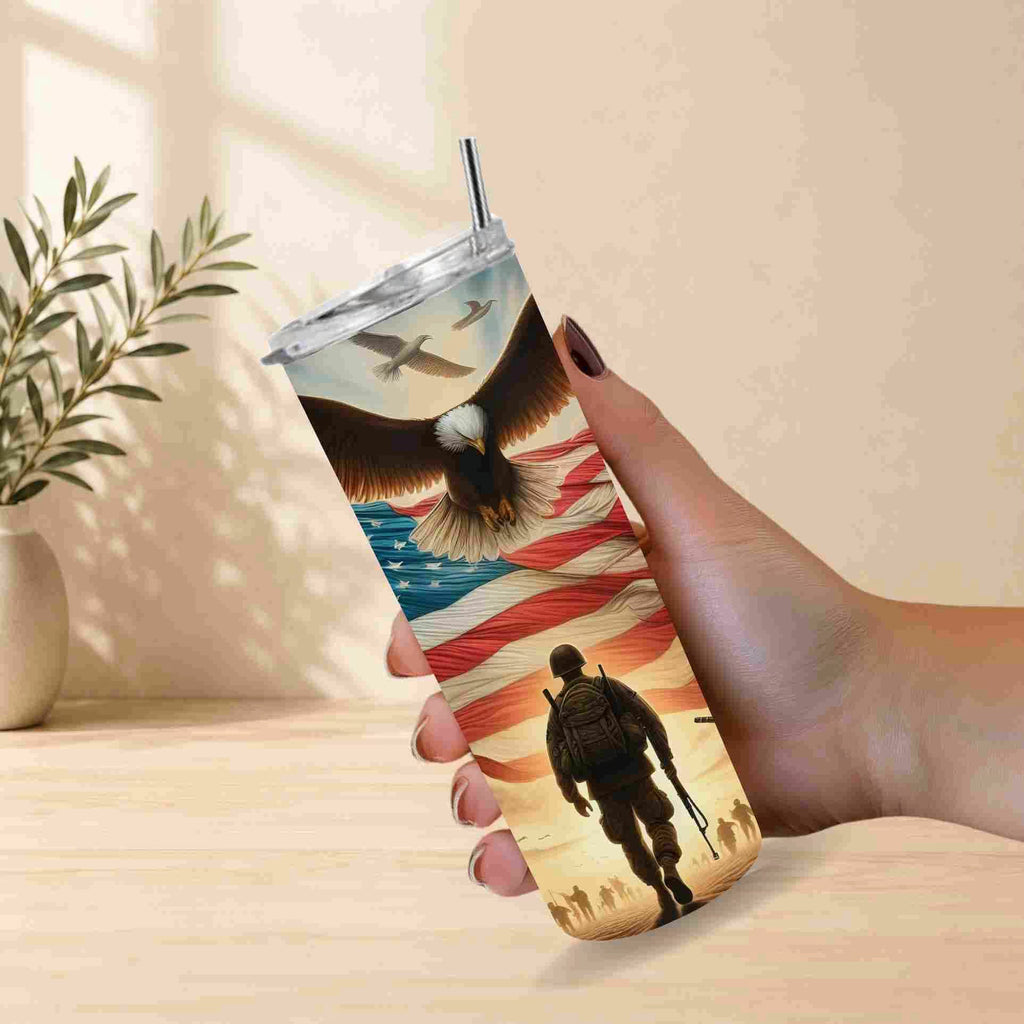 Tumbler with a design of an eagle, American flag, and silhouette of a person holding a gun on a wooden surface.