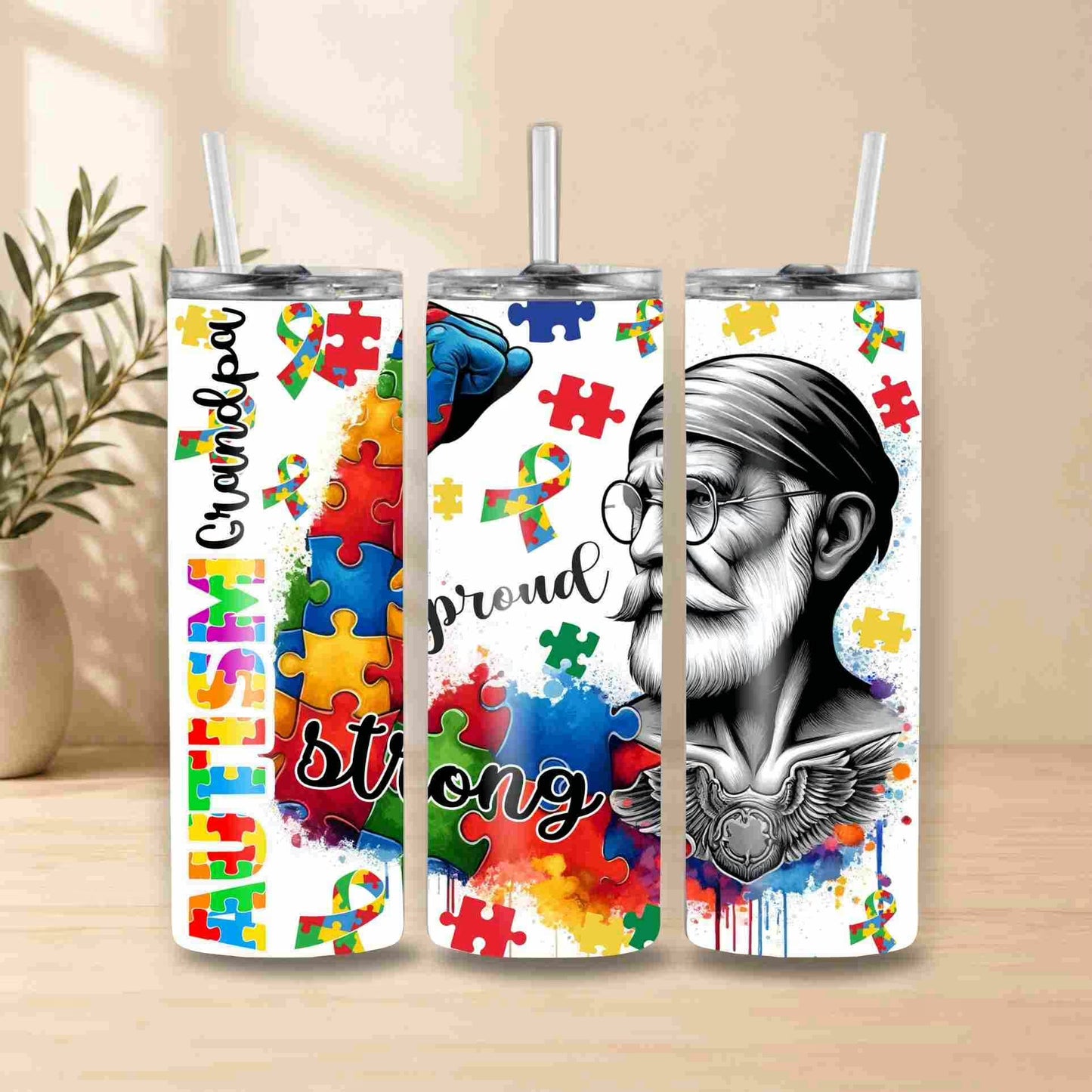 Three tumblers with autism awareness designs featuring colorful puzzles and text on a wooden surface.