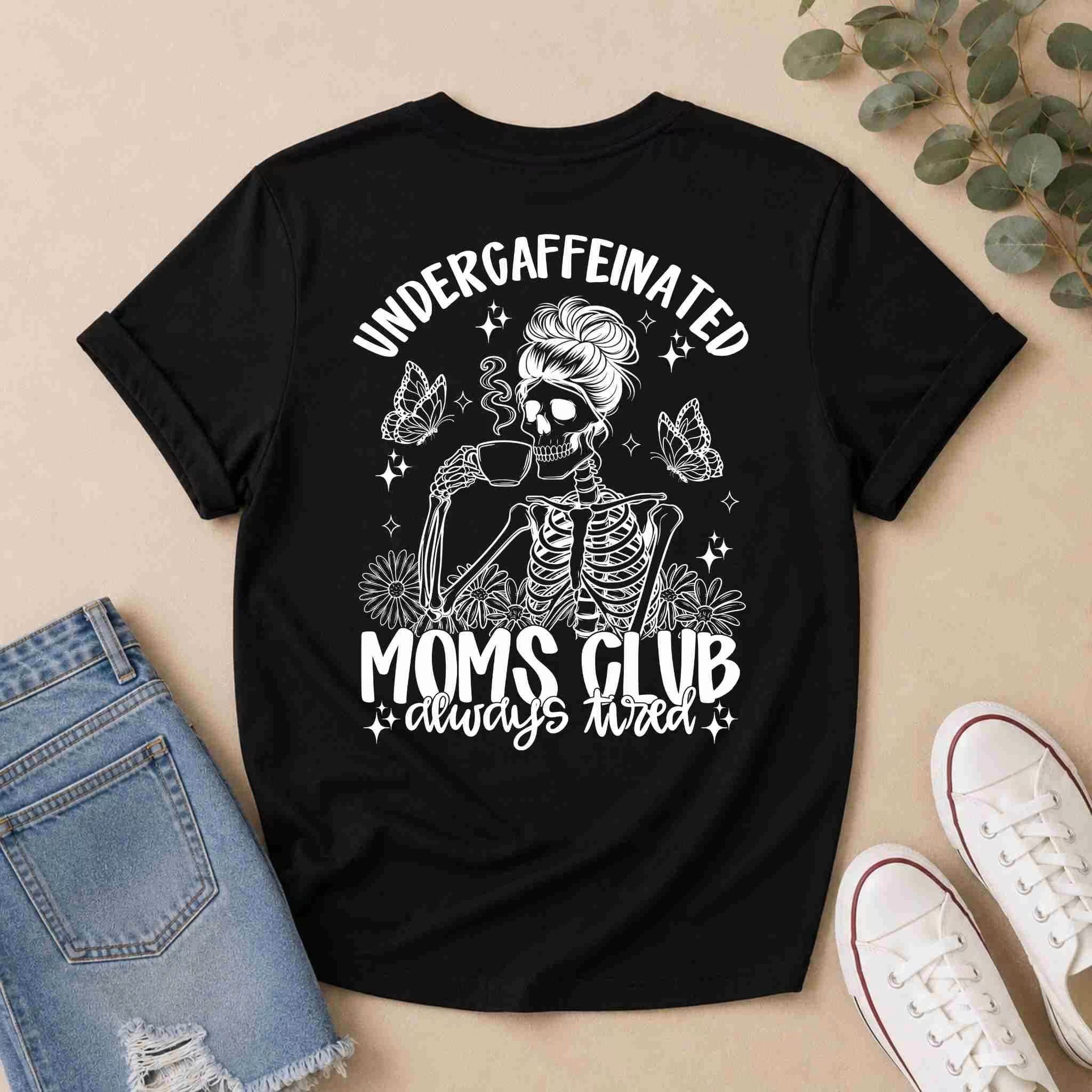 Create a fun outfit with Becca's Banging Designs LLC’s Undercaffeinated Moms Club Shirt—a black tee for tired moms with a skeleton mom, coffee, flowers, and butterflies. Pair it with denim shorts and white sneakers for a cute casual look.