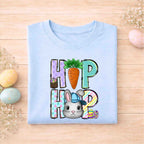 Easter Bunny HOP shirt design featuring a playful bunny, colorful letters, and carrot detail on a light blue youth tee.