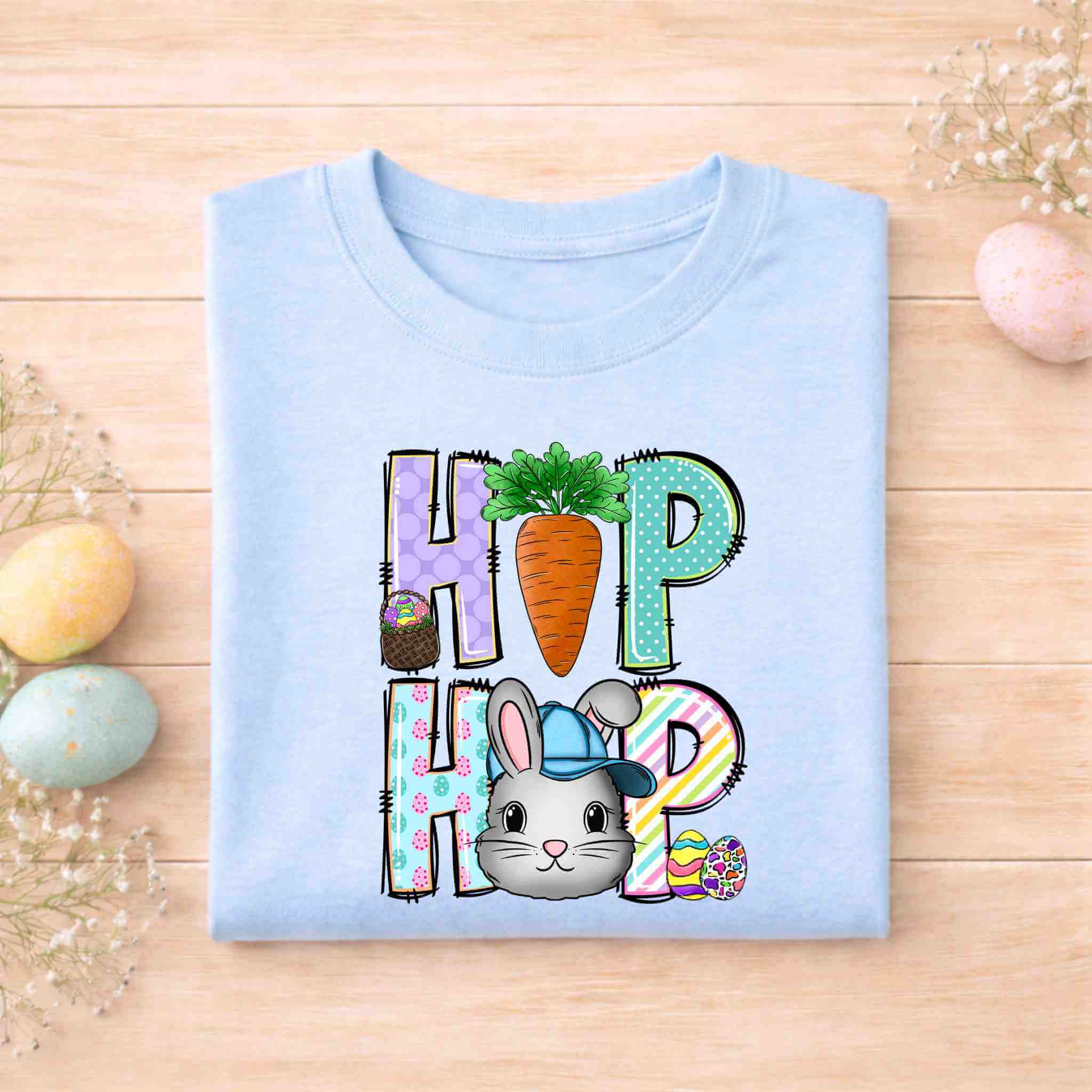 Easter Bunny HOP shirt design featuring a playful bunny, colorful letters, and carrot detail on a light blue youth tee.