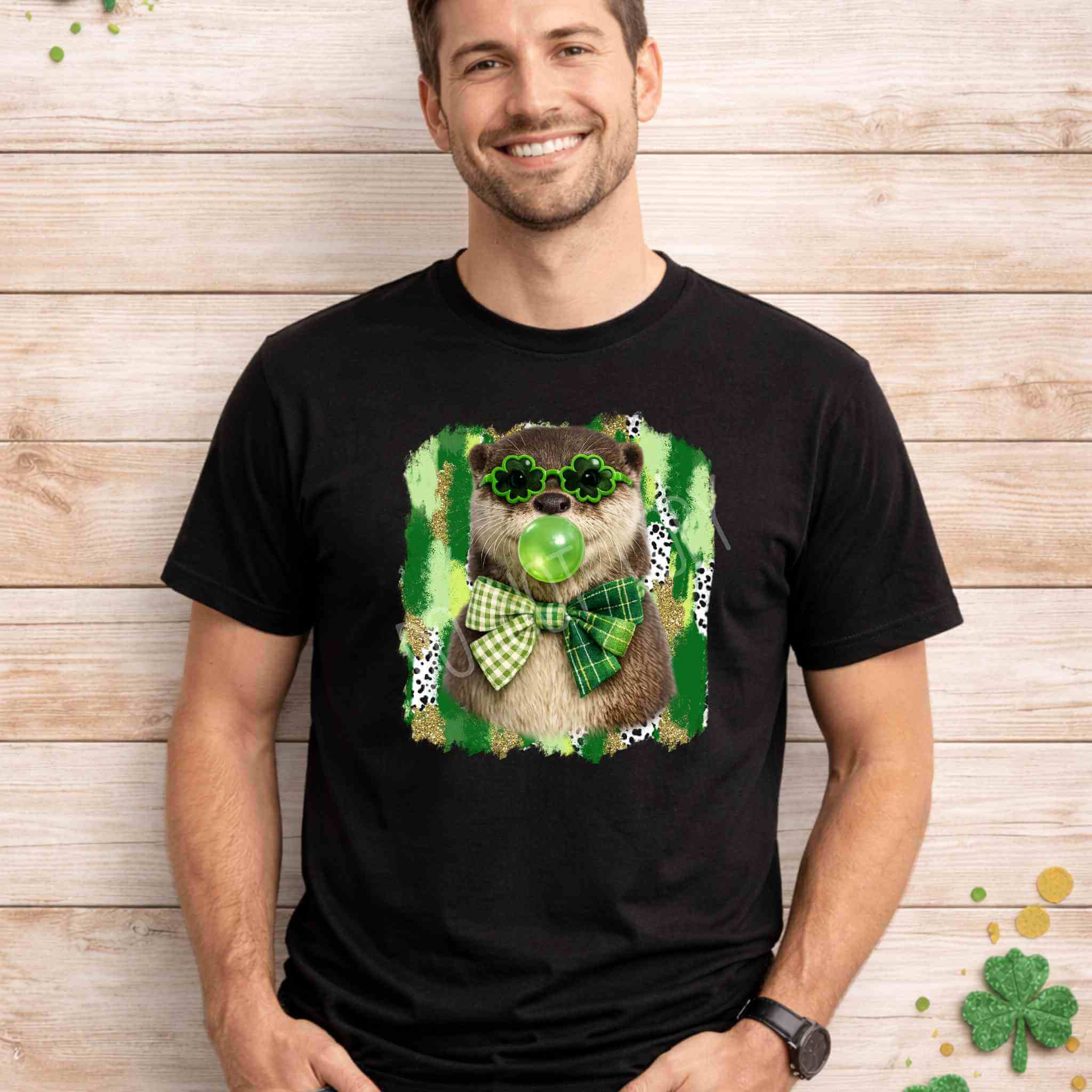 St. Patricks Day Otter Shirt featuring an otter in shamrock glasses and a gingham bow against a green splatter background.