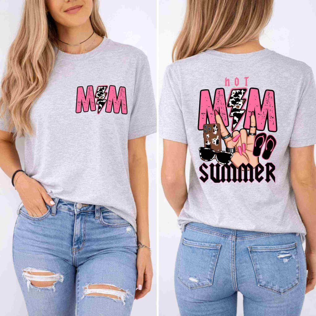A woman wears Becca's Banging Designs LLC's Hot Mom Summer Tee, a light gray shirt with "MIM" in pink and a lightning bolt on the front, "Hot MIM Summer" plus sandals, sunglasses & peace sign on the back, paired with blue ripped jeans.