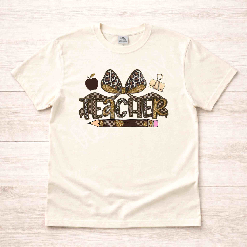 Leopard Love Teacher T-Shirt featuring leopard print bow, apple, paperclip, and pencil design for stylish teachers.