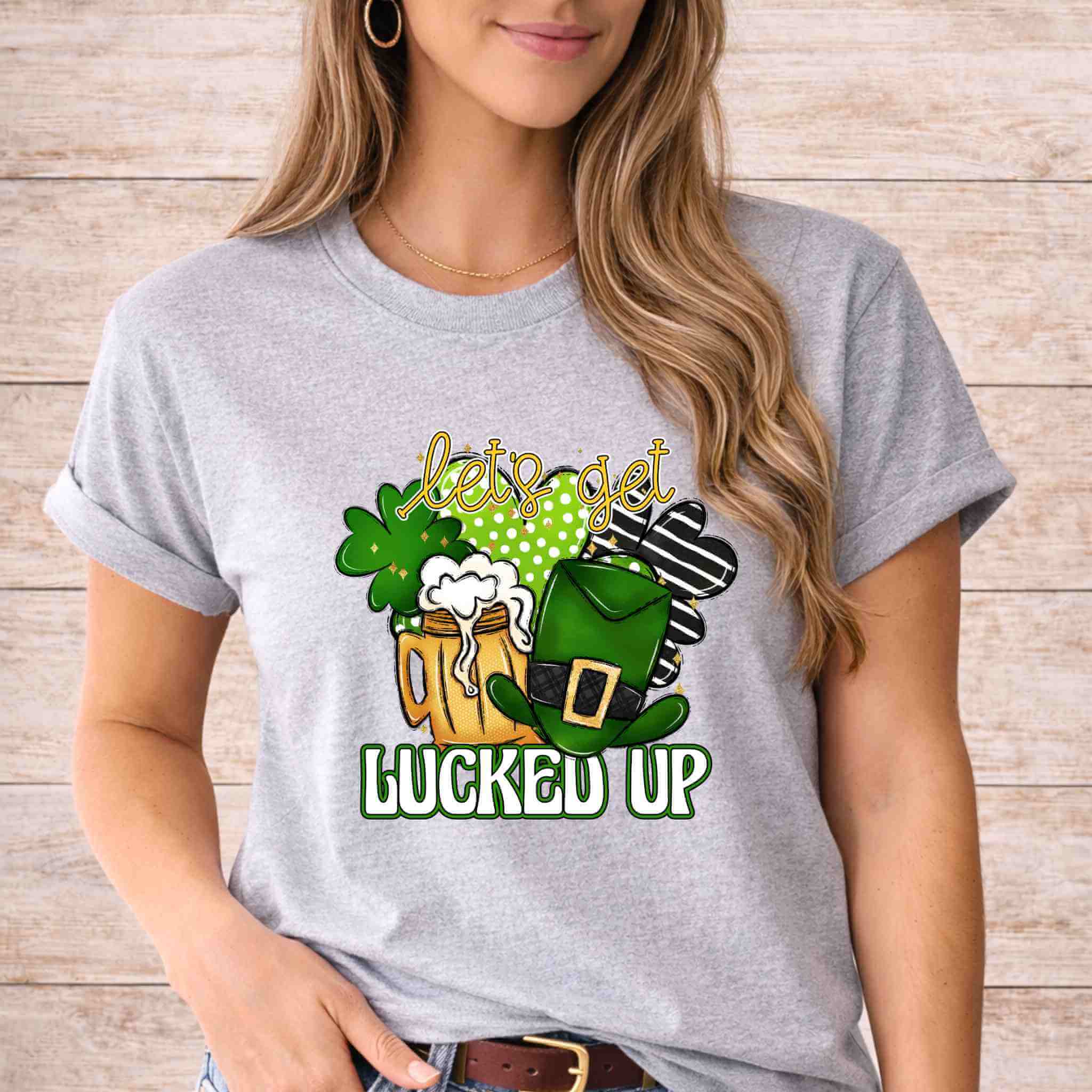 St. Patricks Day shirt featuring a graphic with beer mugs, shamrocks, and leprechaun hat, saying 'let's get lucked up'.