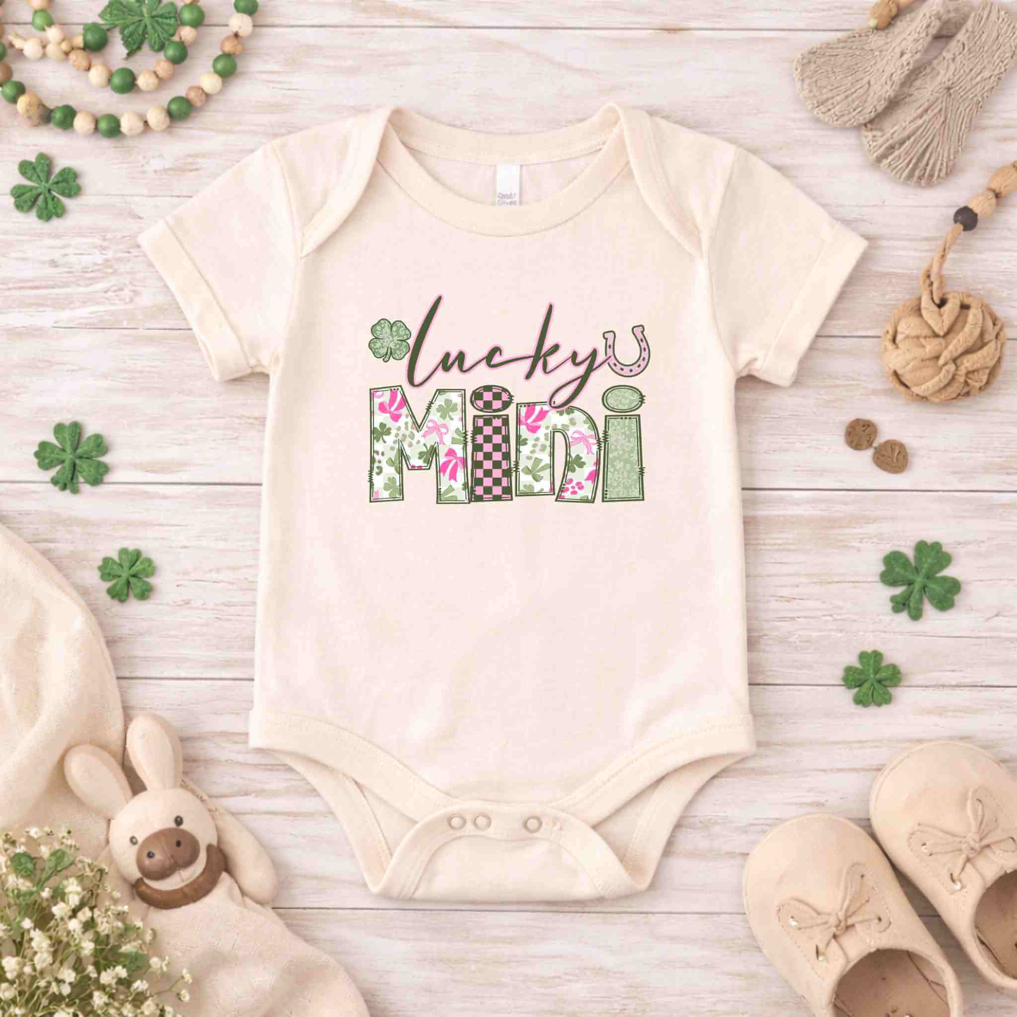 St. Patricks Day Lucky Mini onesie for kids with floral and checkered design on wooden background.