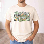St. Patricks Day shirt featuring retro cassette graphic with shamrocks and checkered accents on a cream tee.