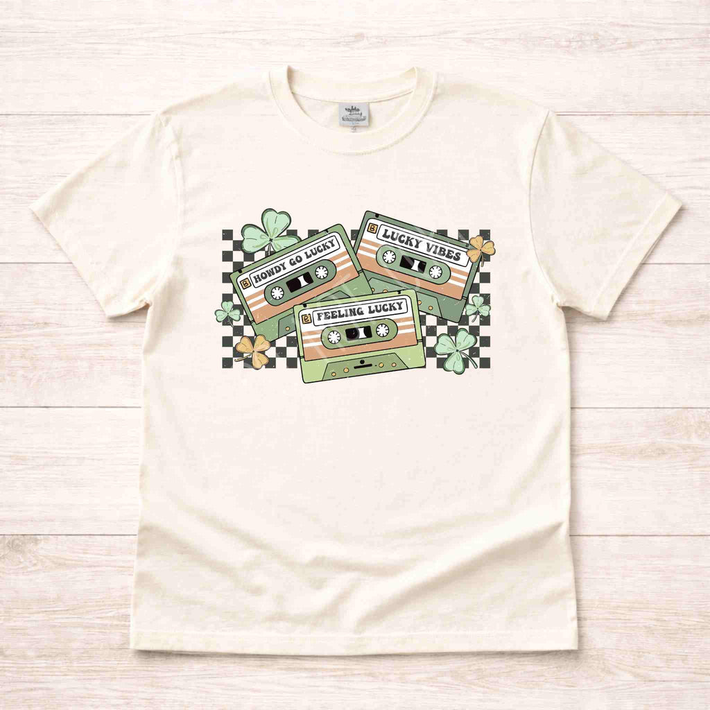 St. Patricks Day shirt featuring a retro cassette tape graphic with shamrocks and checkered accents.