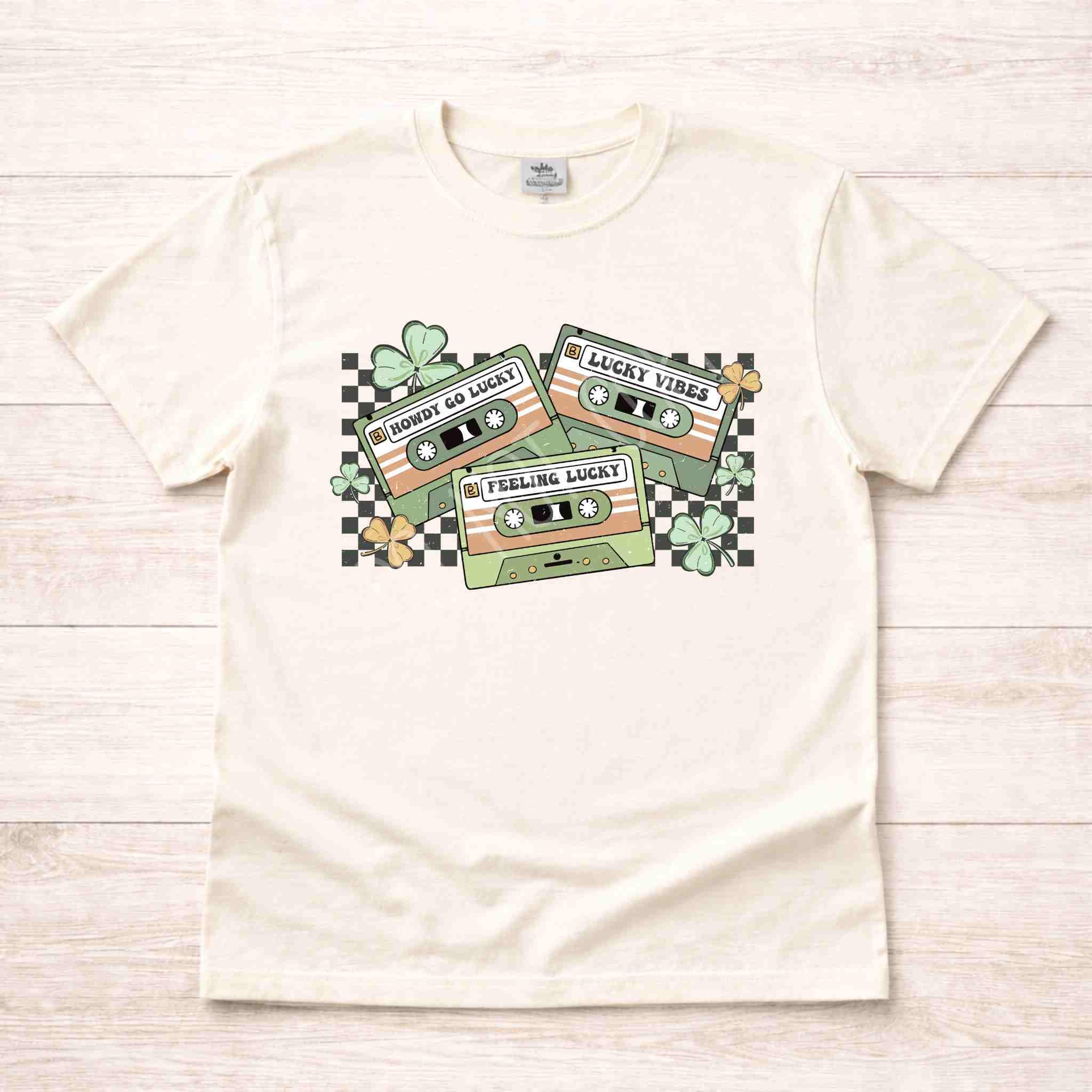 St. Patricks Day shirt featuring a retro cassette tape graphic with shamrocks and checkered accents.