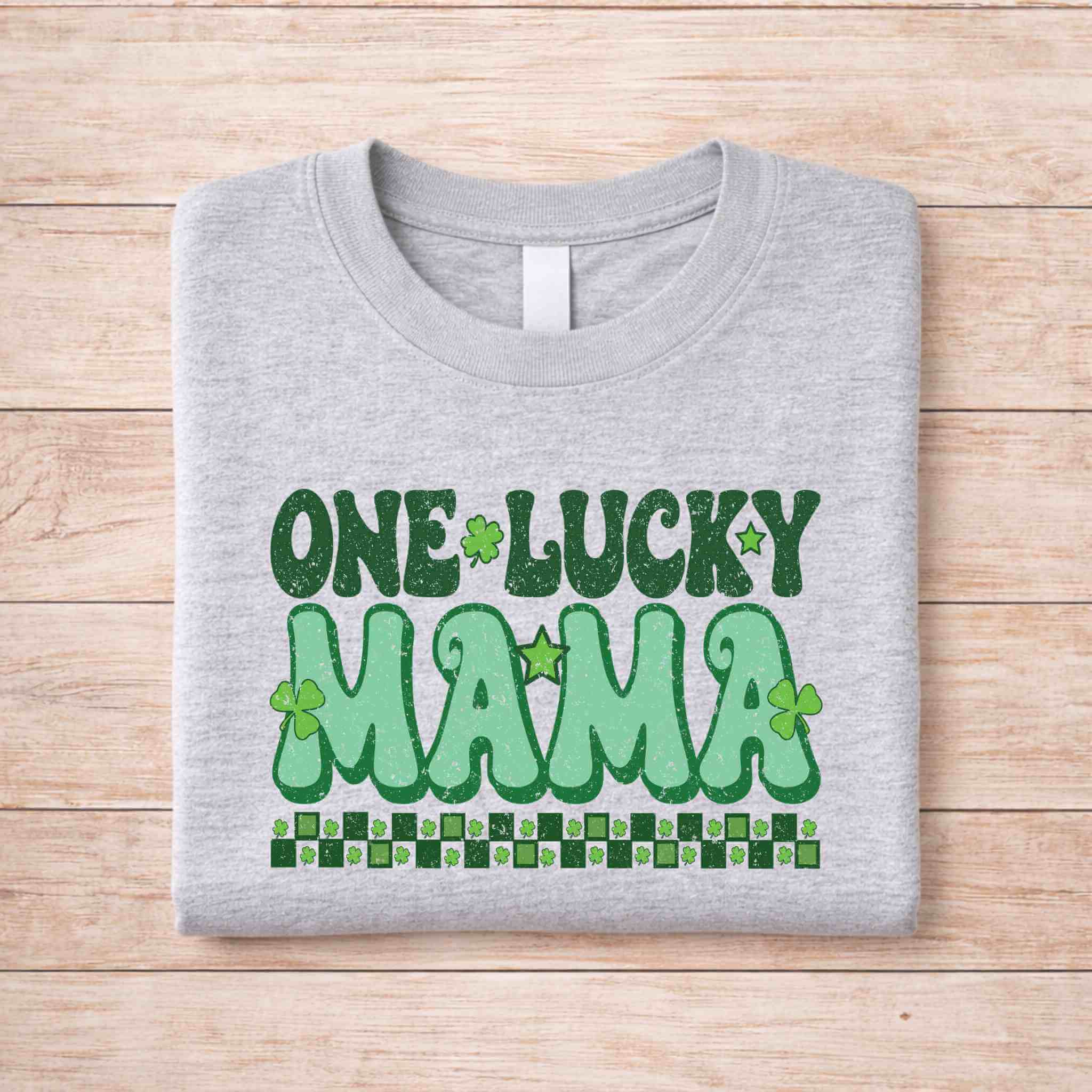 St. Patricks Day One Lucky Mama shirt featuring retro lettering and shamrock accents on a gray background
