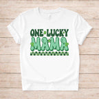 St. Patricks Day One Lucky Mama t-shirt with retro green lettering and shamrock accents on a white fabric.