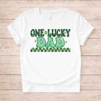 St. Patricks Day One Lucky Dad shirt with retro-inspired green lettering and shamrock accents on a white tee.
