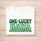 St. Patricks Day One Lucky Nana tee shirt with festive shamrocks and green details on a white background.