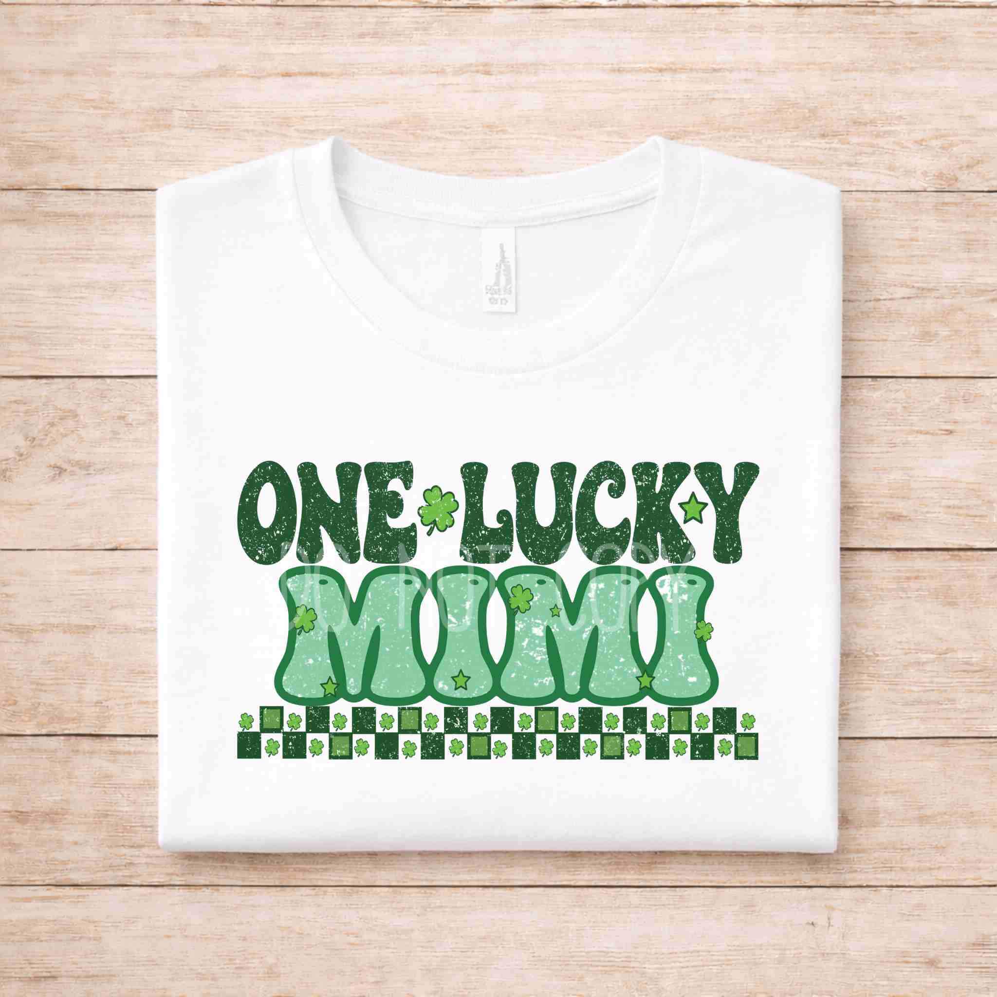 St. Patricks Day One Lucky MUMI tee with green distressed lettering and shamrock accents on a white shirt.
