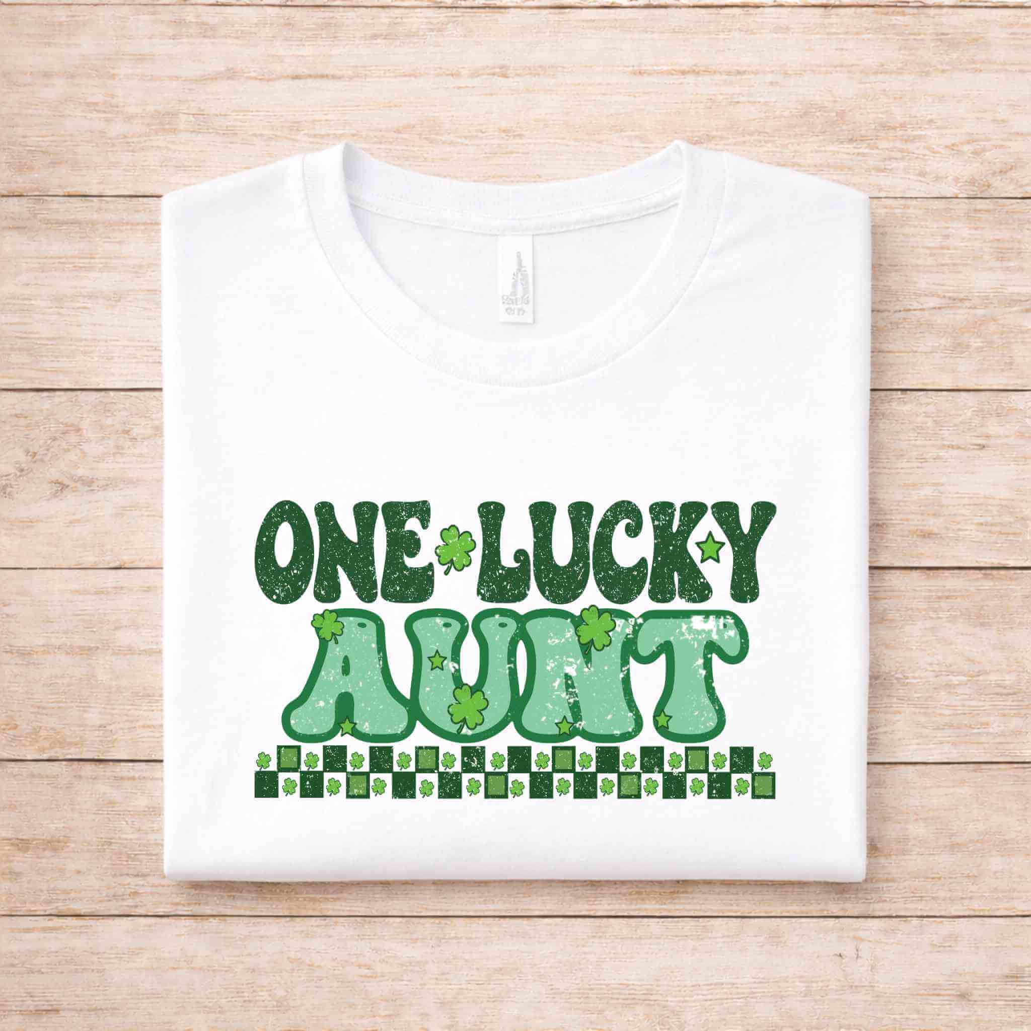 St. Patricks Day One Lucky Aunt shirt with green lettering and shamrock designs on a white background.