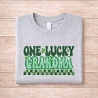 St. Patricks Day matching tee featuring retro lettering for One Lucky Grandma on a gray shirt.