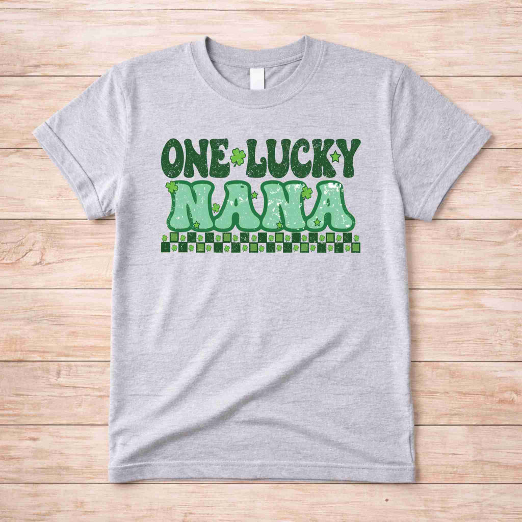 St. Patricks Day One Lucky Nana tee with retro lettering and shamrock accents on gray fabric.