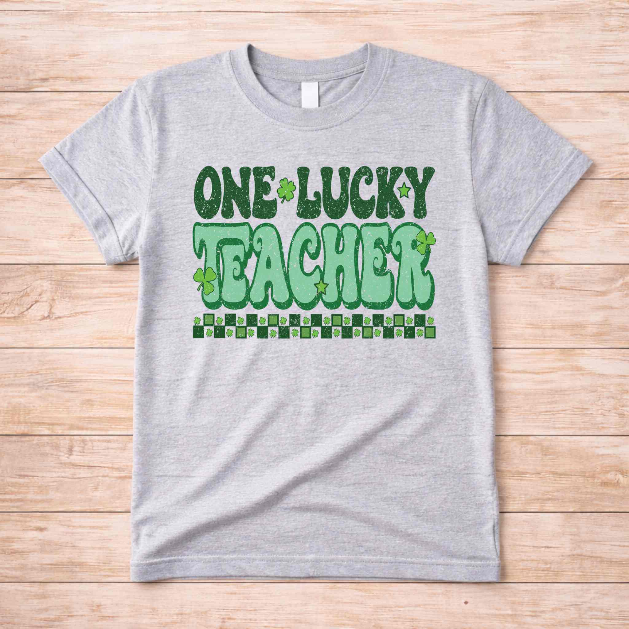 St. Patricks Day Teacher T-Shirt with One Lucky Teacher graphic and shamrocks in green on a grey tee.