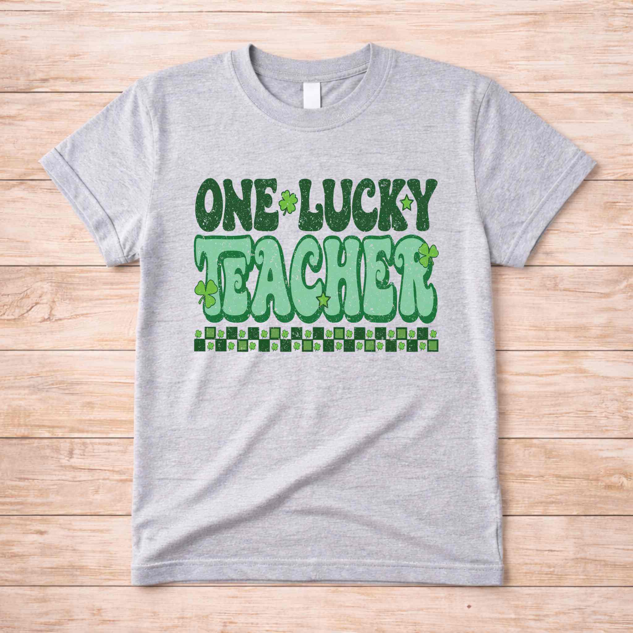 St. Patricks Day Teacher T-Shirt featuring 'One Lucky Teacher' graphic with shamrocks on a gray tee.