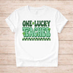 St. Patricks Day Teacher T-Shirt featuring bold green lettering and shamrock graphics on a white tee.