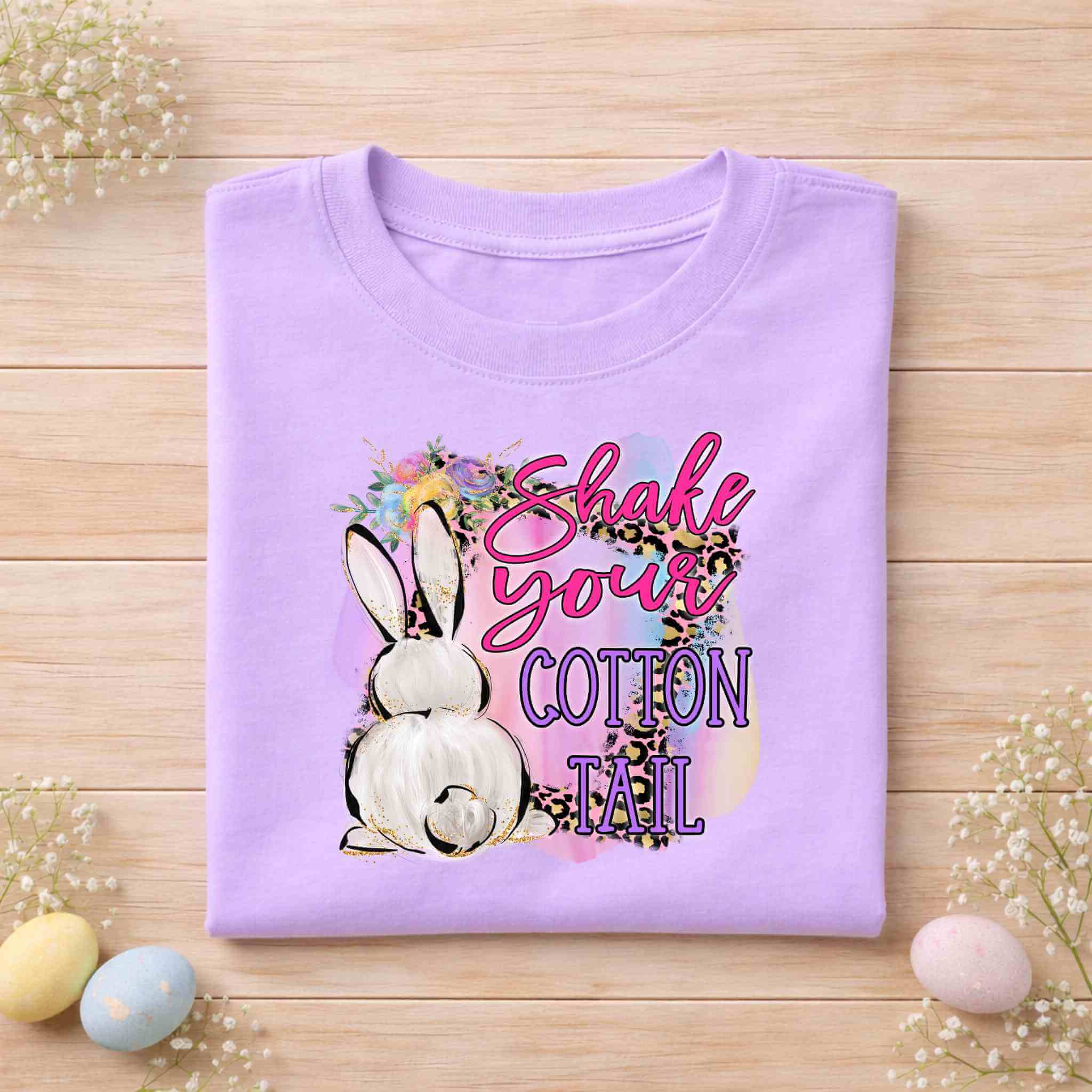 Funny Easter graphic tee with a fluffy bunny and colorful design that says 'Shake Your Cotton Tail' for Easter celebrations.