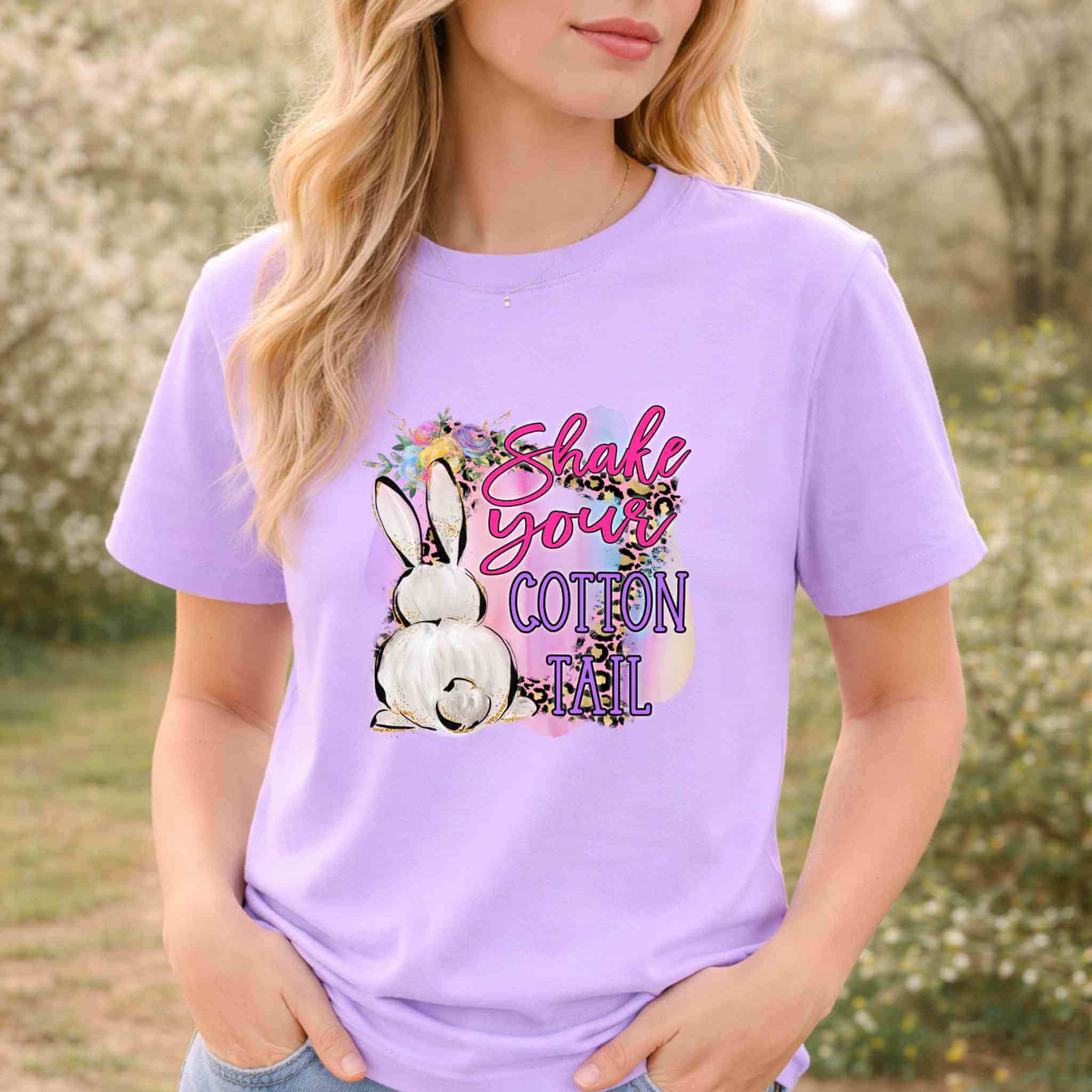 Woman wearing a purple funny Easter graphic tee with a bunny graphic and the phrase 'Shake Your Cotton Tail'.